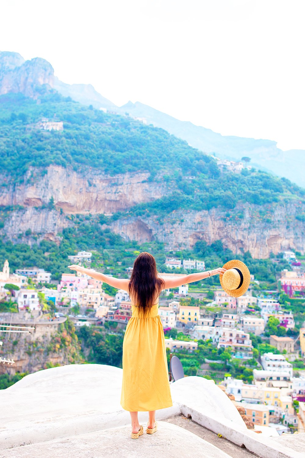 Summer holiday in Italy. Young woman in Positano village on the background, Amalfi Coast, Italy